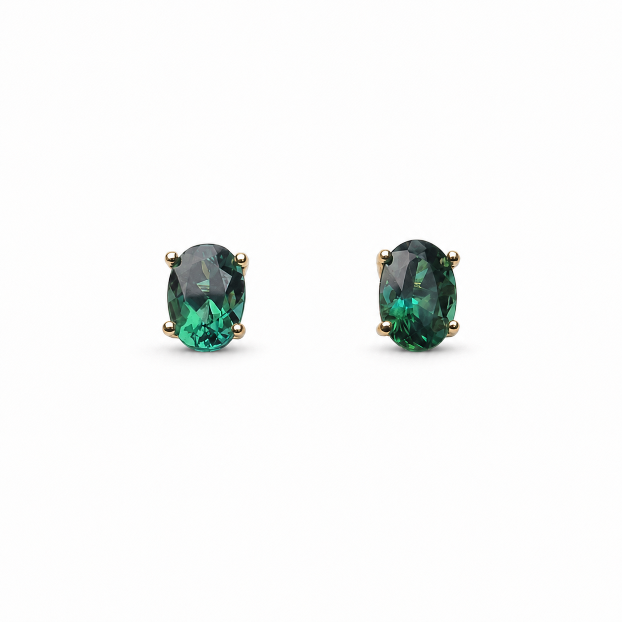Custom lagoon tourmaline pendant and stud earrings set in 14K yellow gold, featuring 3.34 total carats of oval blue-green tourmalines.
