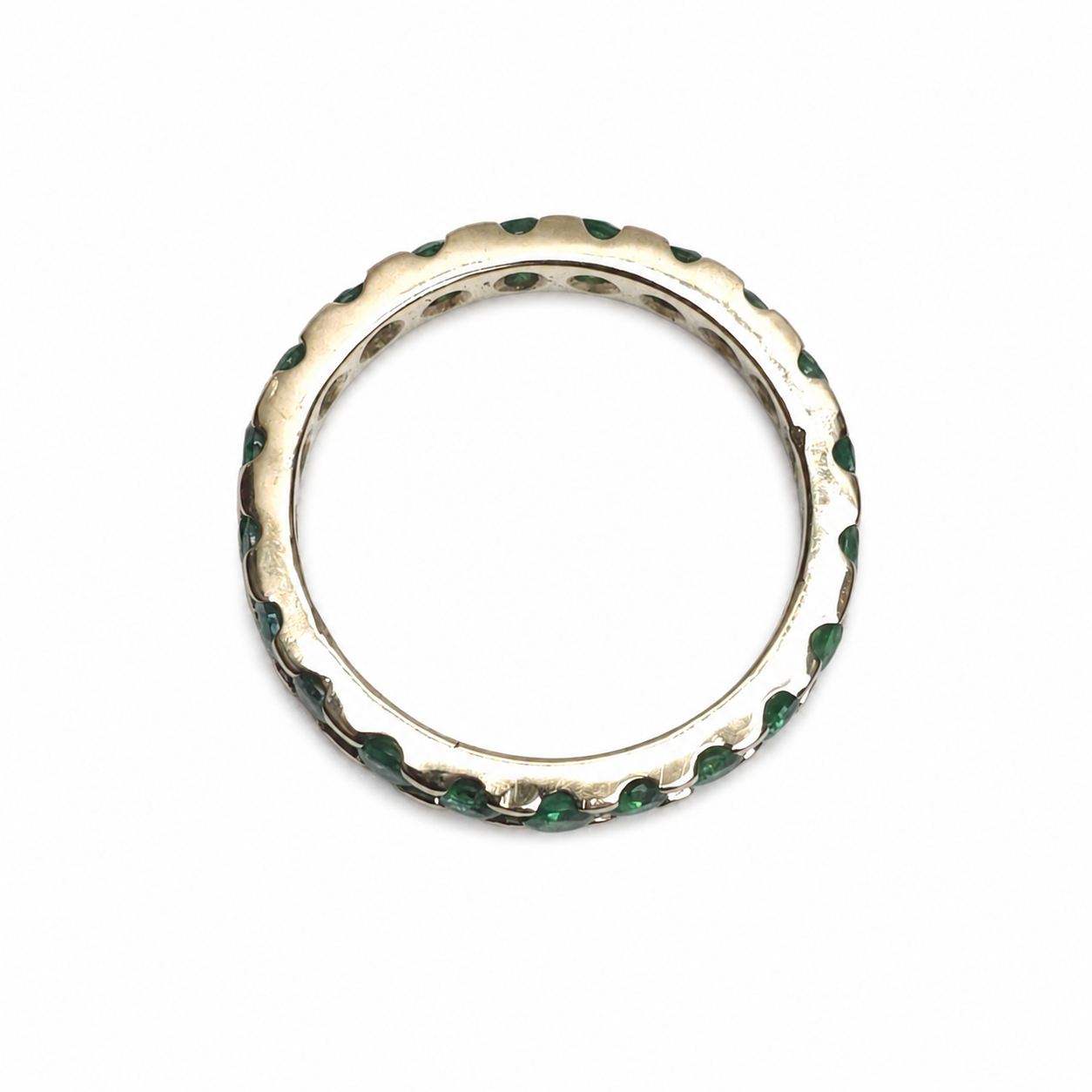 Full eternity band featuring 0.93 carats of round Colombian emeralds in a shared-prong 14K yellow gold setting.