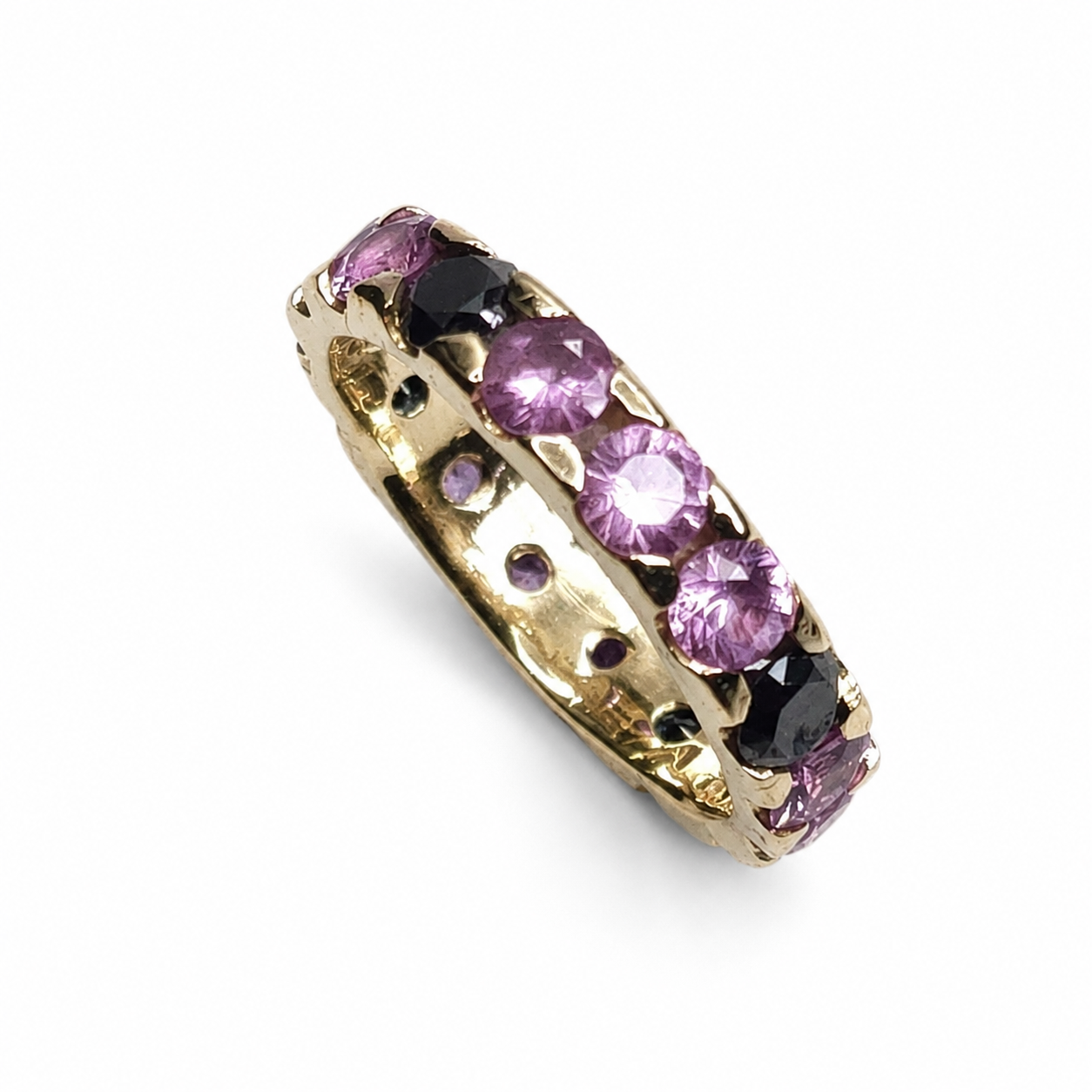 Full eternity band featuring 2.00 carats of round pink sapphires and 0.65 carats of black diamonds set in 14K yellow gold.