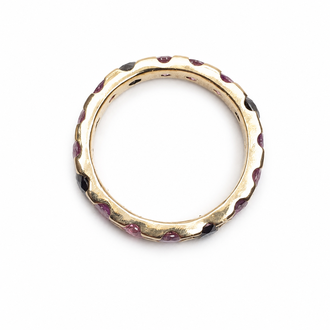 Full eternity band featuring 2.00 carats of round pink sapphires and 0.65 carats of black diamonds set in 14K yellow gold.