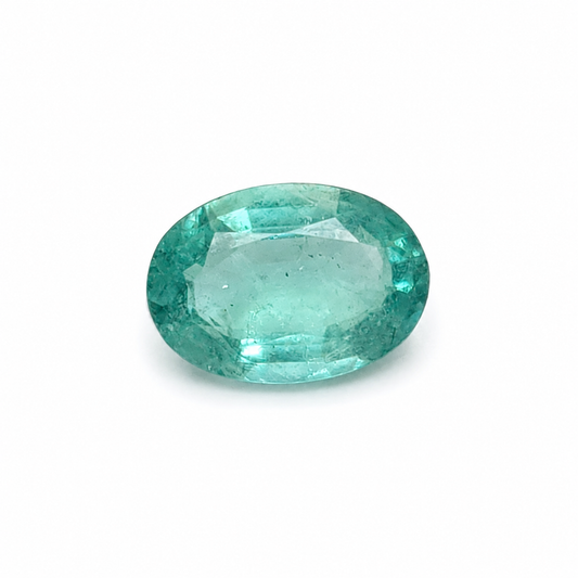Loose 1.32 carat oval Zambian emerald displaying luminous blue-green colour and naturally occurring internal inclusions.