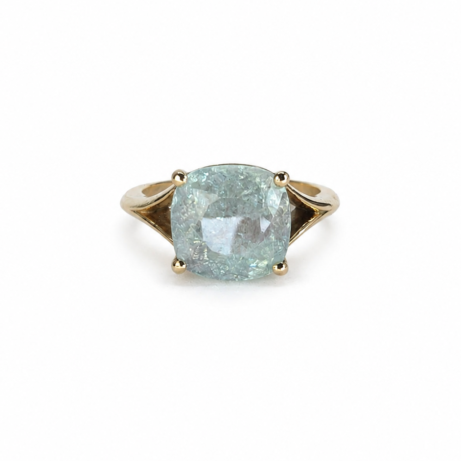 The Eye of Paraíba features a certified 4.43ct ice-blue Paraíba tourmaline set in a sculpted 14K yellow gold statement prong-set ring.