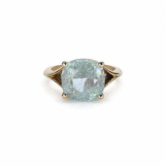 The Eye of Paraíba features a certified 4.43ct ice-blue Paraíba tourmaline set in a sculpted 14K yellow gold statement prong-set ring.